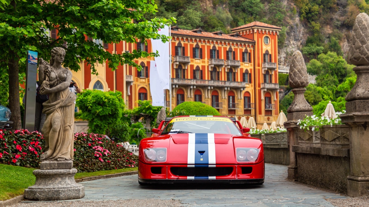 Red sports car parked outside a villa
